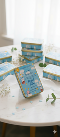 Collection of small blue tins with gold accents on a white surface.