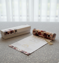 Floral-themed Scroll Wedding Cards with a box, paper, and roll on a textured surface.