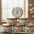 Set of bid floral-patterned with gold lids on a wooden surface
