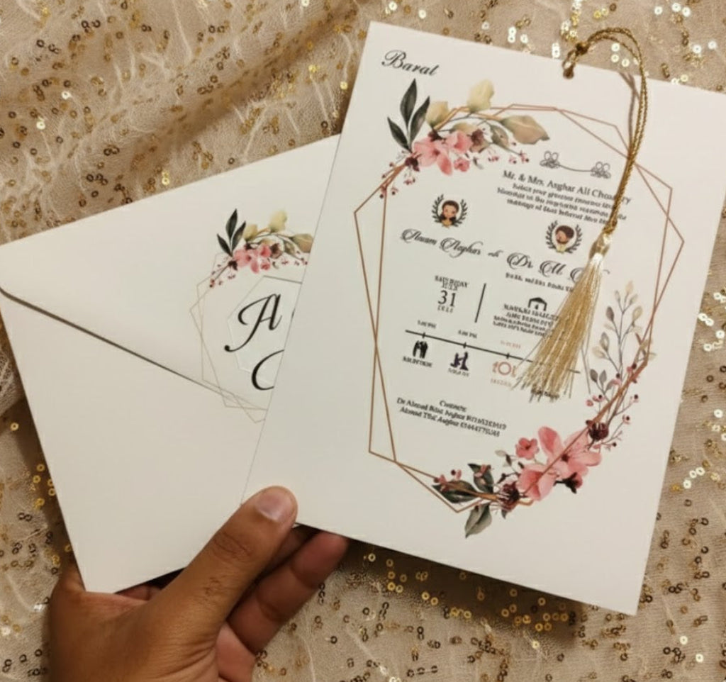 Wedding invitation card with floral design held by a hand on a glittery background
