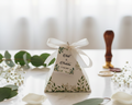 Wedding favor box with floral design on a white surface with greenery