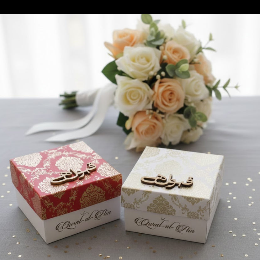 Two decorative bid boxes with floral arrangements on a light surface